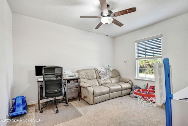 carpeted office space featuring ceiling fan