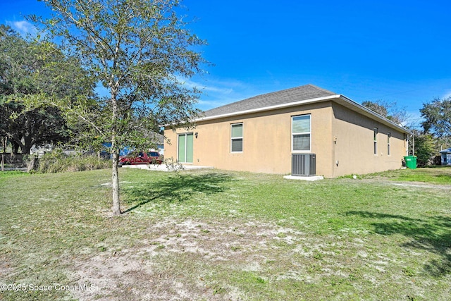 view of side of home with central AC and a lawn