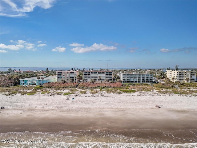 birds eye view of property with a water view and a view of the beach