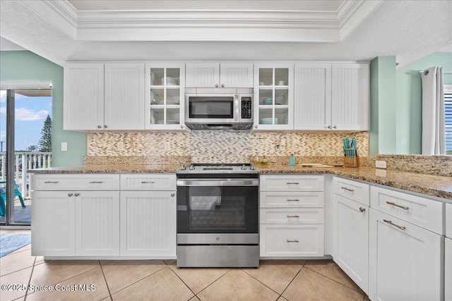 kitchen with white cabinetry, light tile patterned floors, light stone countertops, and appliances with stainless steel finishes