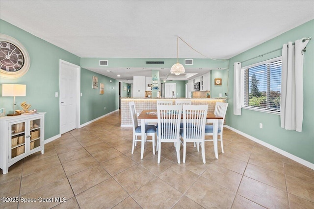 tiled dining space featuring a textured ceiling