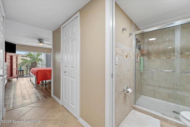 bathroom featuring an enclosed shower, ceiling fan, tile patterned floors, and toilet