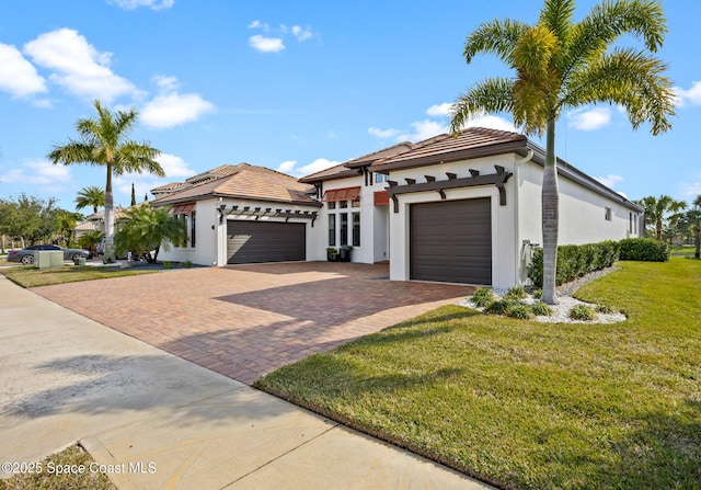 mediterranean / spanish home featuring a garage and a front lawn