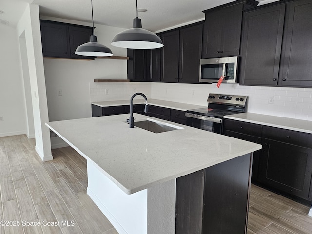 kitchen featuring sink, a center island with sink, and appliances with stainless steel finishes