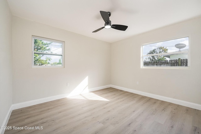 spare room with ceiling fan, plenty of natural light, and light hardwood / wood-style floors