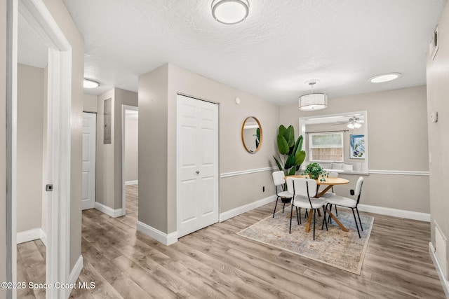 dining space featuring a textured ceiling and light wood-type flooring