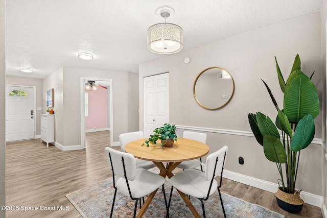 dining area featuring a textured ceiling and light wood-type flooring