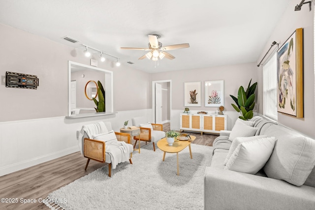 living room with ceiling fan, wood-type flooring, and rail lighting