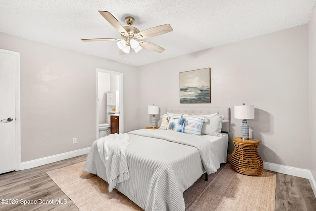 bedroom featuring ceiling fan, connected bathroom, light hardwood / wood-style floors, and a textured ceiling