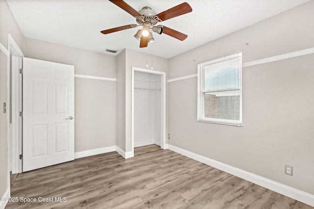 unfurnished bedroom with hardwood / wood-style flooring, a closet, and ceiling fan