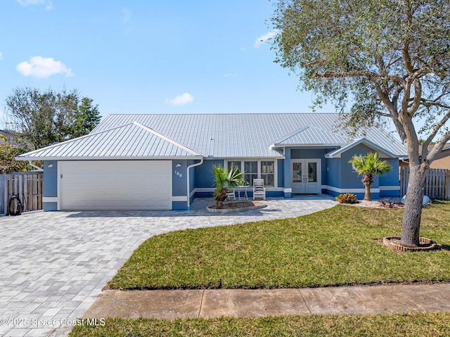 view of front of house with a garage, a front yard, and french doors