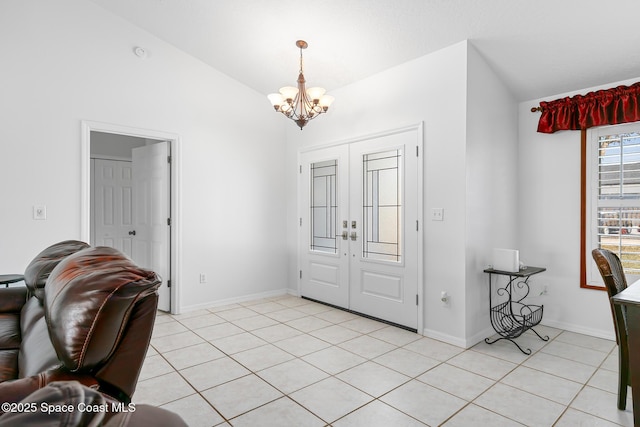 tiled entryway with lofted ceiling, french doors, and a chandelier