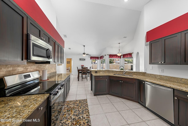 kitchen with stone counters, appliances with stainless steel finishes, sink, backsplash, and kitchen peninsula