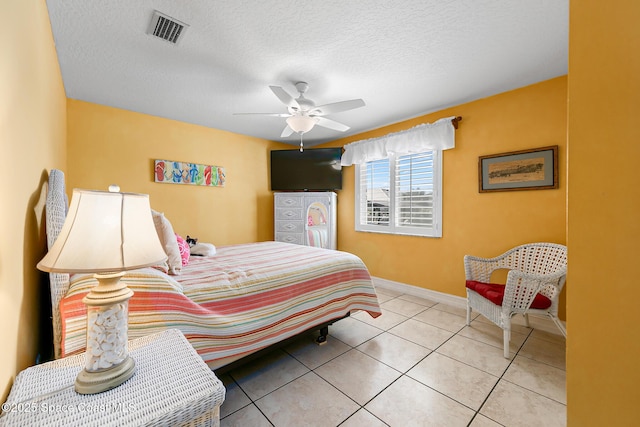 tiled bedroom with ceiling fan and a textured ceiling