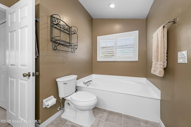 bathroom featuring tile patterned flooring, a washtub, and toilet