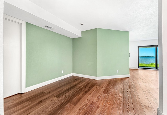 unfurnished room with wood-type flooring