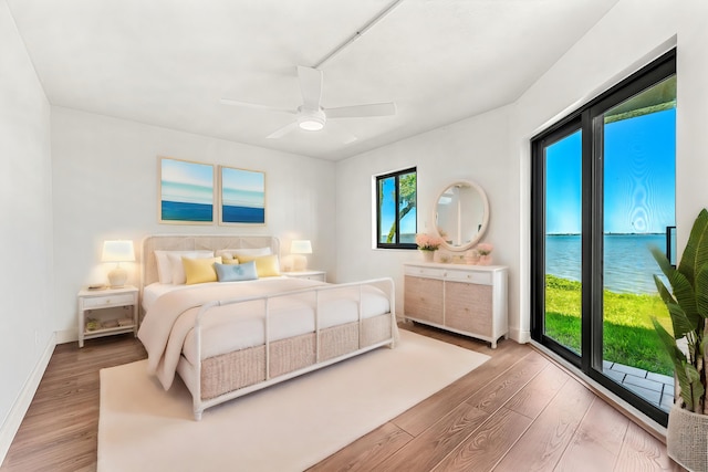 bedroom featuring a water view, ceiling fan, and hardwood / wood-style flooring