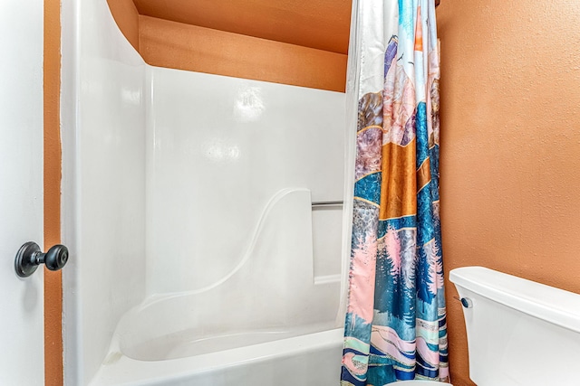 bathroom featuring shower / bath combination with curtain and toilet