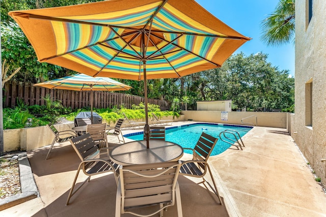 view of swimming pool featuring area for grilling and a patio area