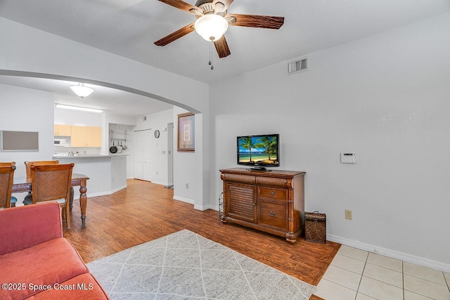 living room with ceiling fan and light hardwood / wood-style flooring