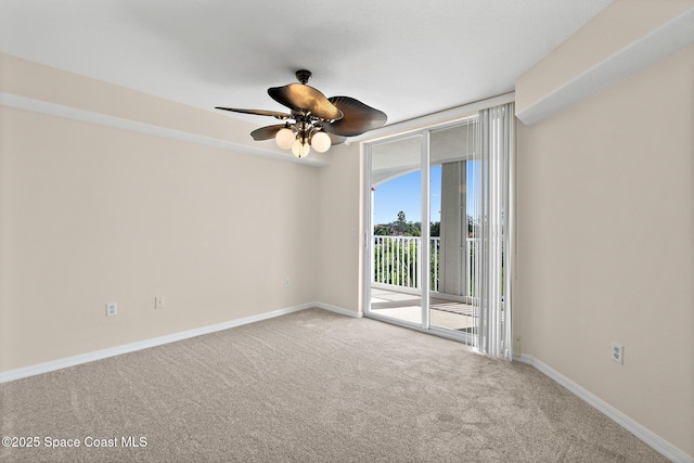 carpeted spare room with a wall of windows and ceiling fan