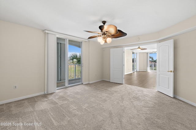 carpeted spare room featuring ceiling fan