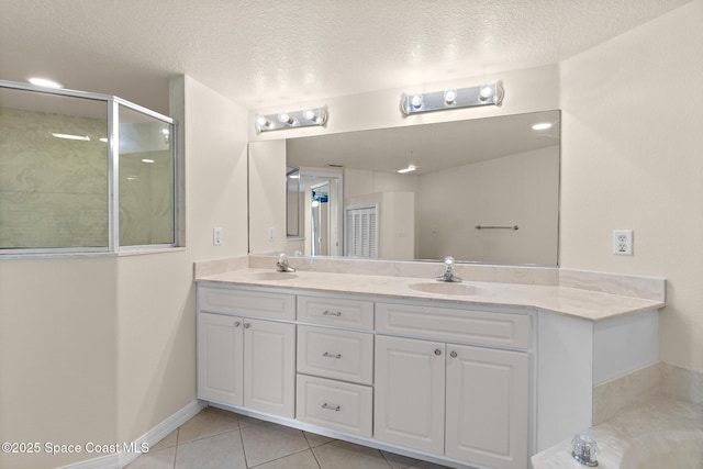 bathroom with tile patterned floors, plus walk in shower, vanity, and a textured ceiling