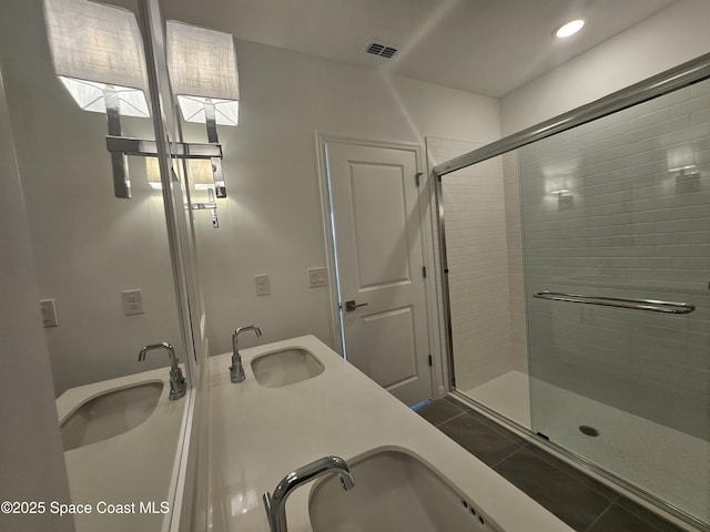 bathroom with an enclosed shower, vanity, and tile patterned floors