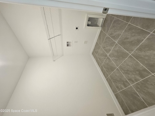 laundry area featuring hookup for a washing machine, dark tile patterned floors, and hookup for an electric dryer