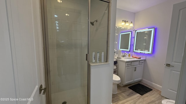 bathroom featuring vanity, toilet, a shower with shower door, and wood-type flooring