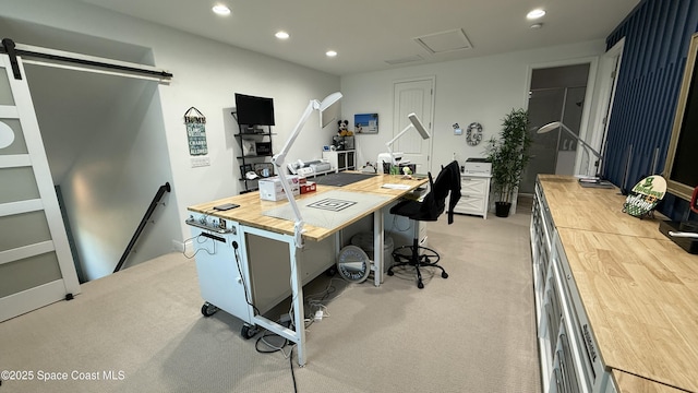 home office featuring light colored carpet and a barn door