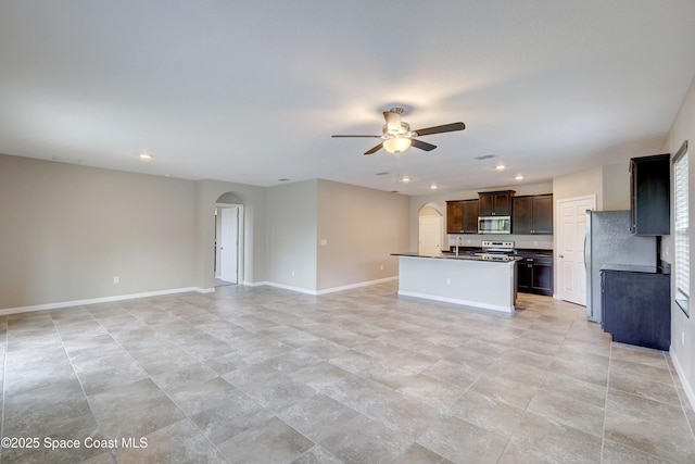 kitchen featuring appliances with stainless steel finishes, sink, a kitchen island with sink, dark brown cabinetry, and ceiling fan