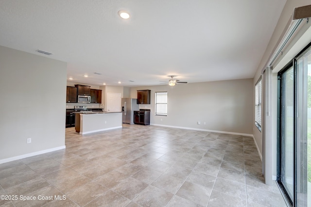 unfurnished living room with ceiling fan and sink