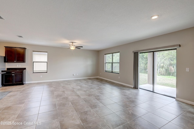 unfurnished living room featuring ceiling fan, a textured ceiling, and light tile patterned floors