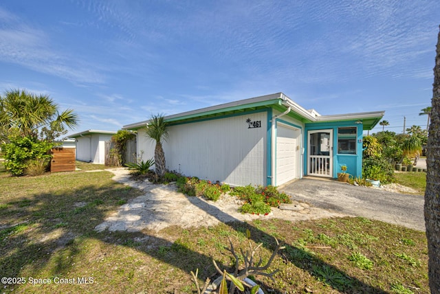 view of property exterior with a garage and a yard