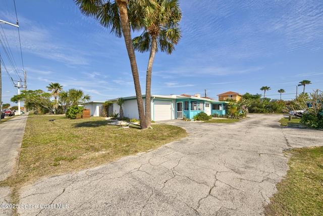 single story home featuring a garage and a front yard