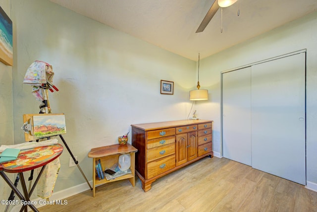 bedroom featuring ceiling fan, a closet, and light hardwood / wood-style flooring