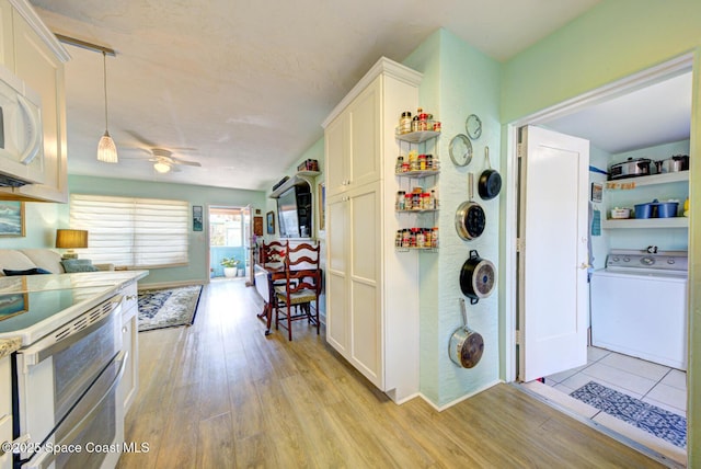 kitchen with washer / clothes dryer, white cabinetry, and light hardwood / wood-style floors