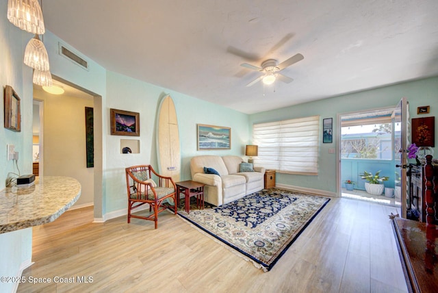 living room with light hardwood / wood-style flooring and ceiling fan