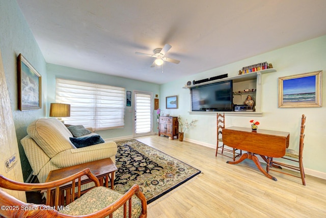 living room with ceiling fan and light hardwood / wood-style flooring