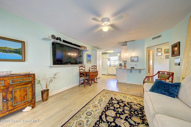 living room with ceiling fan and light hardwood / wood-style flooring