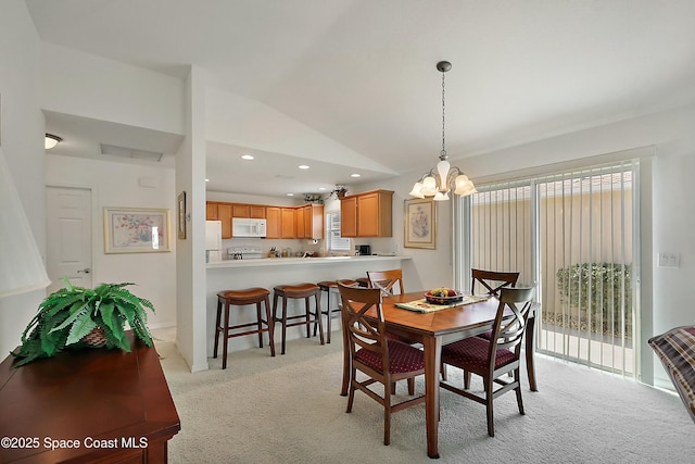 dining area featuring an inviting chandelier, lofted ceiling, and light carpet