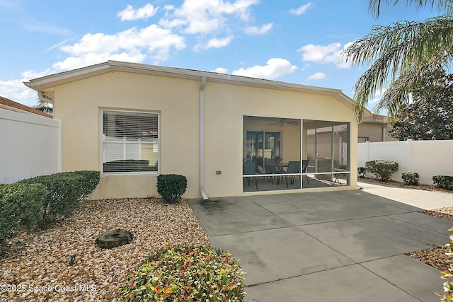 back of property featuring a sunroom, a patio, and ceiling fan