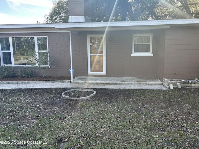 423 Longfellow Blvd, Lakeland, FL 33803 - rear view of house featuring brick siding and a chimney