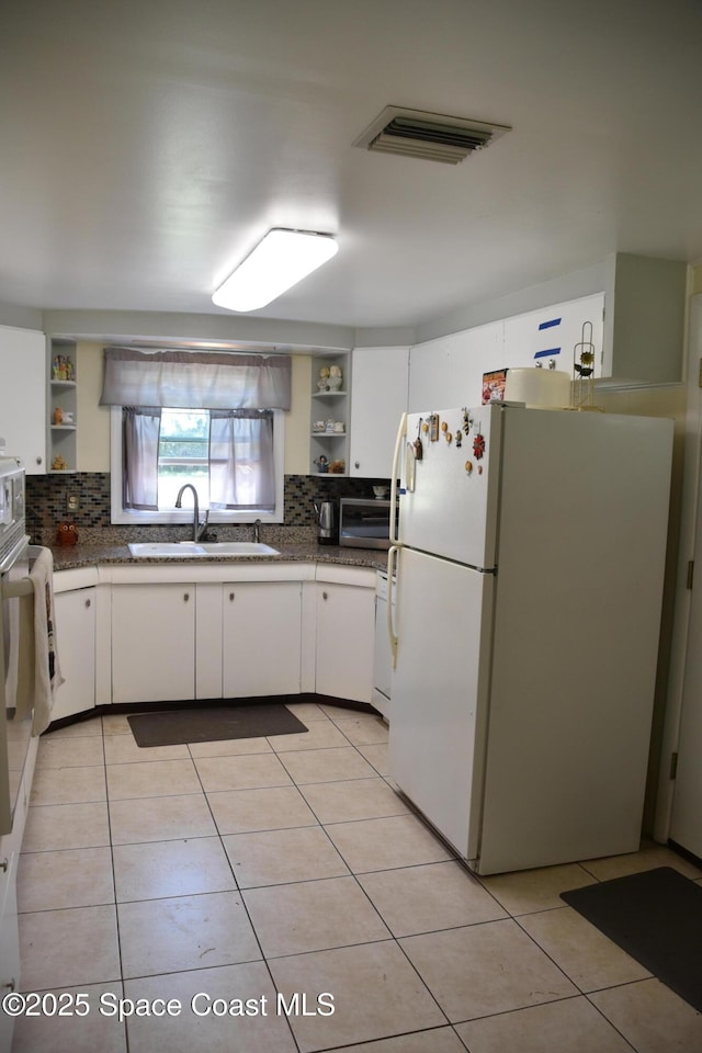 423 Longfellow Blvd, Lakeland, FL 33803 - kitchen with freestanding refrigerator, open shelves, a sink, and dark countertops