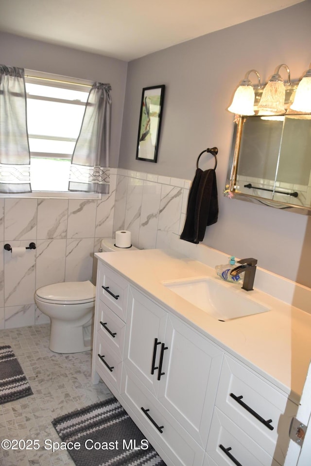 423 Longfellow Blvd, Lakeland, FL 33803 - bathroom with vanity, toilet, tile walls, and a wainscoted wall