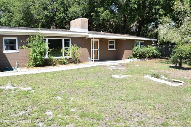 423 Longfellow Blvd, Lakeland, FL 33803 - ranch-style home featuring a front yard and a chimney