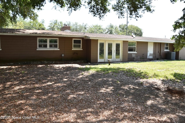 423 Longfellow Blvd, Lakeland, FL 33803 - rear view of property with a chimney, french doors, central air condition unit, and a lawn