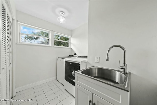 washroom with cabinets, sink, light tile patterned floors, and washing machine and clothes dryer