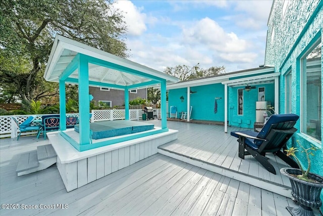 wooden deck featuring a gazebo and ceiling fan